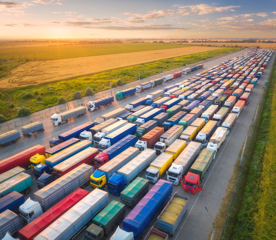 Aerial view of trucks lined up beside fields