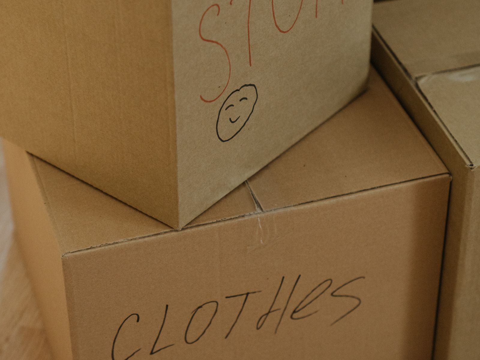 Two stacked cardboard boxes labelled by hand