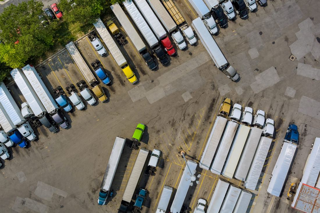 Rows of trucks and trailers in a yard, seen from above